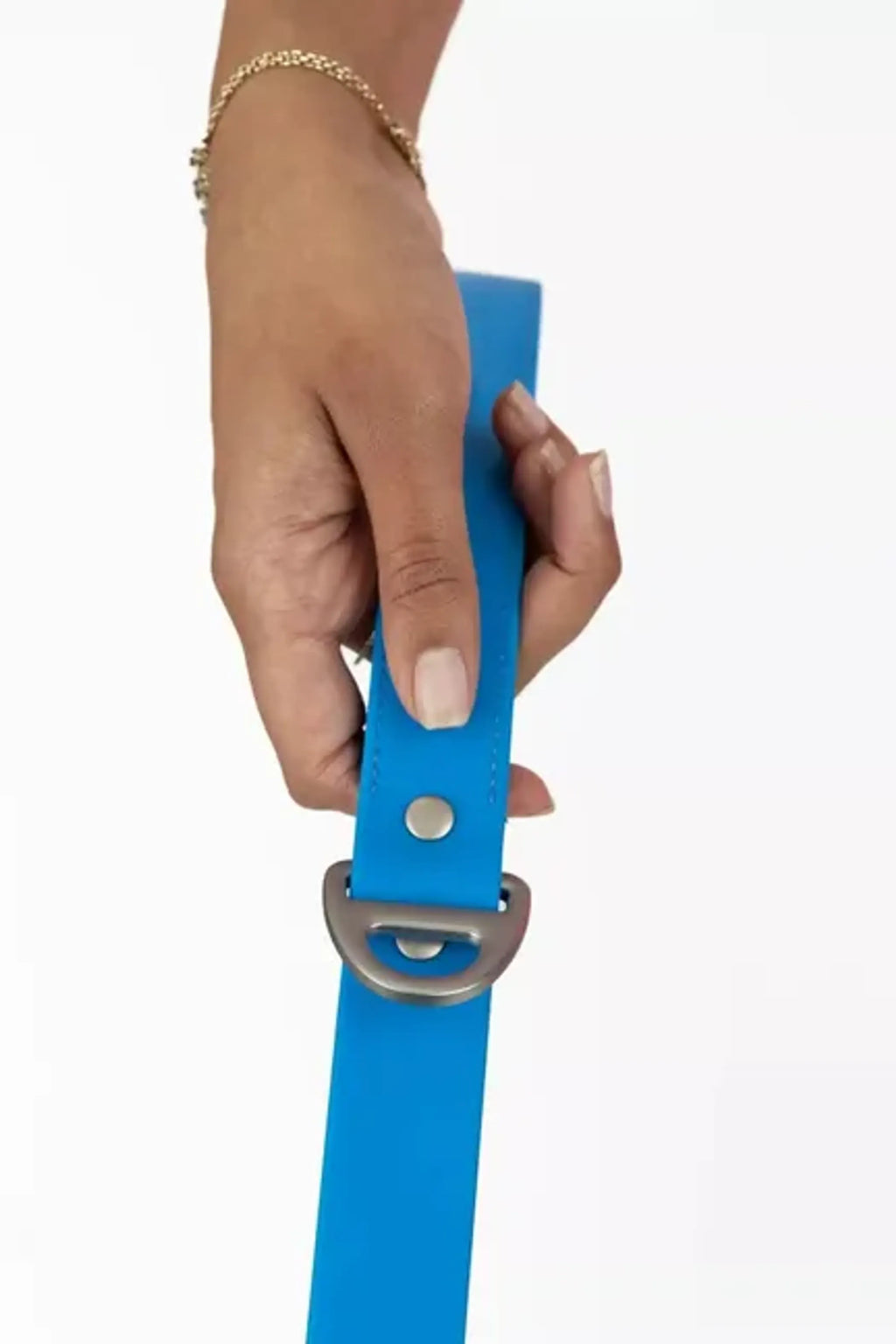 Hand holding a blue belt with a metal buckle on a white background