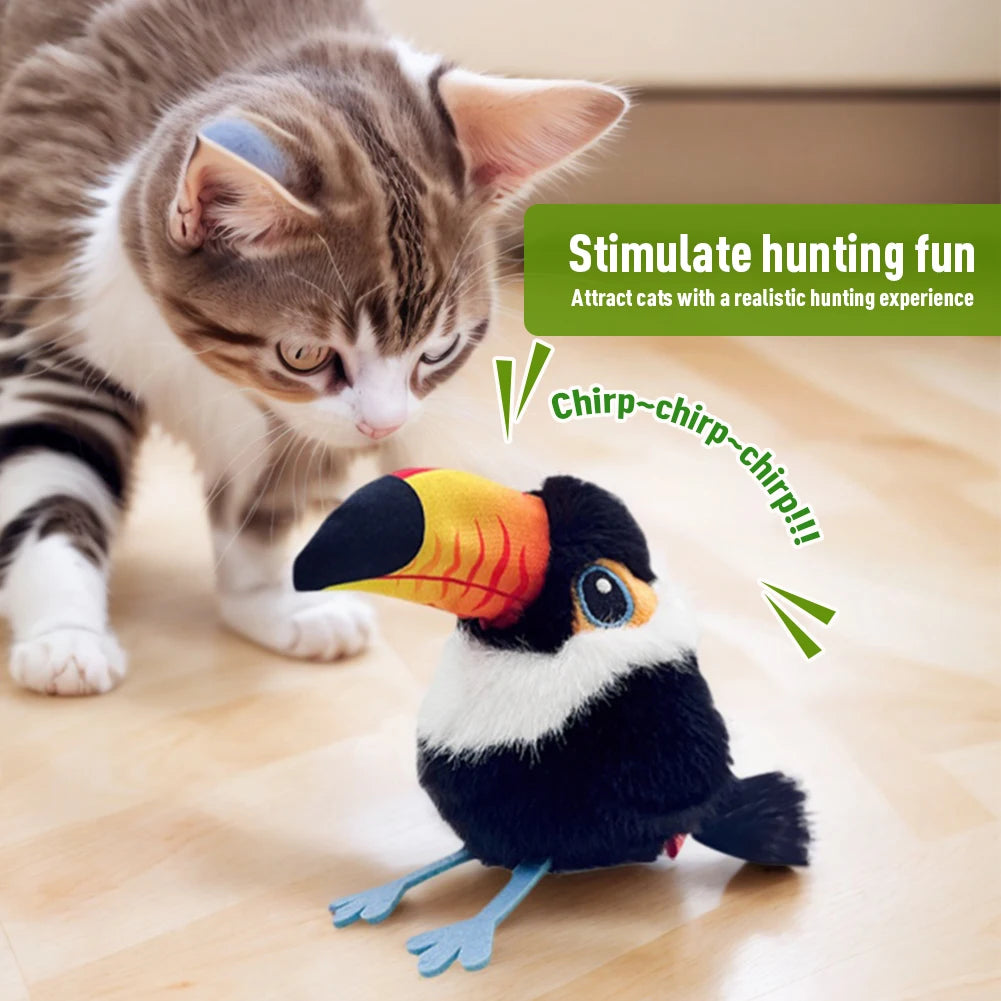 A curious kitten on a wooden floor watches the Pet Interactive Flapping Chirping Bird Cat Toy. Text reads, "Stimulate hunting fun with realistic movement and sounds. Attract cats and keep them active. Chirp-chirp-chirp!!!.