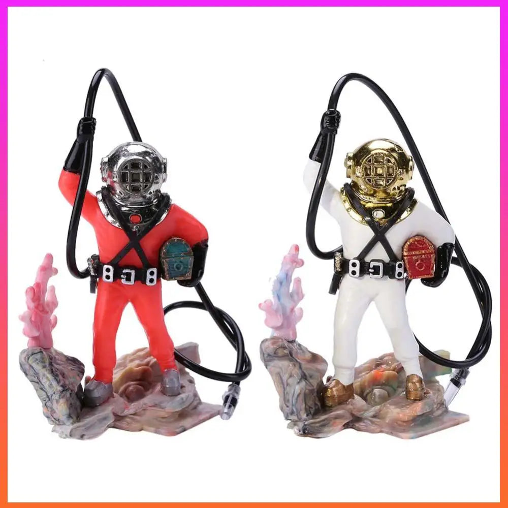 Two figurines of scuba divers in red and white suits with diving helmets on a decorative base.