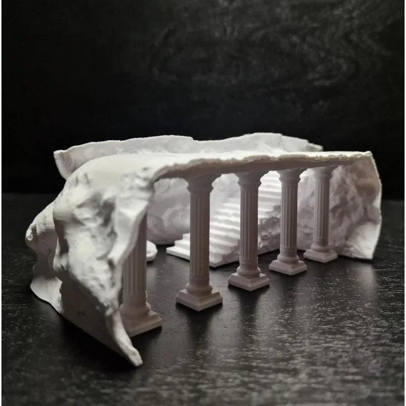 White marble-like sculpture of a classical arch with columns on a dark surface